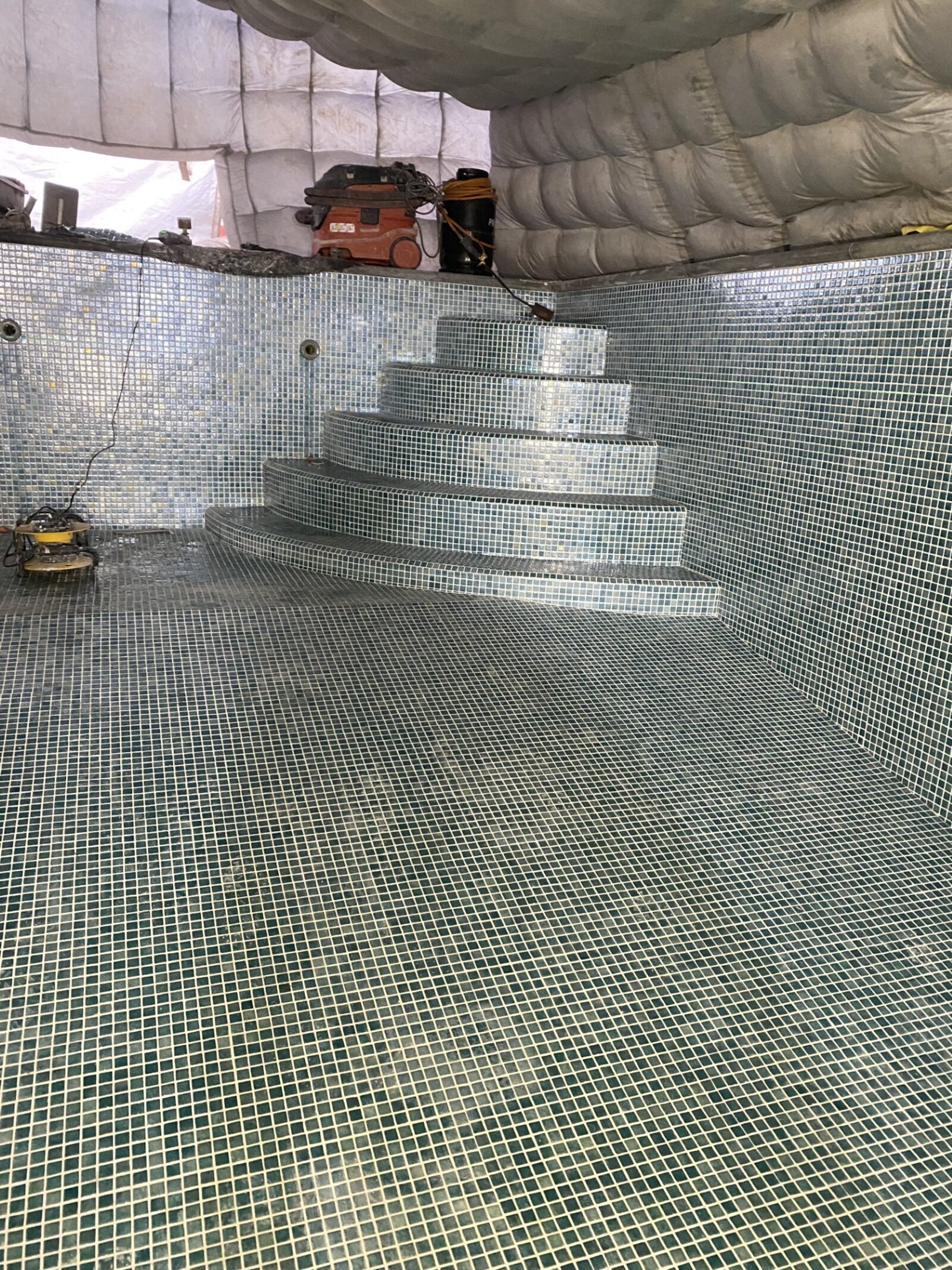 Pose de la mosaïque de verre sur parois, escalier et fond