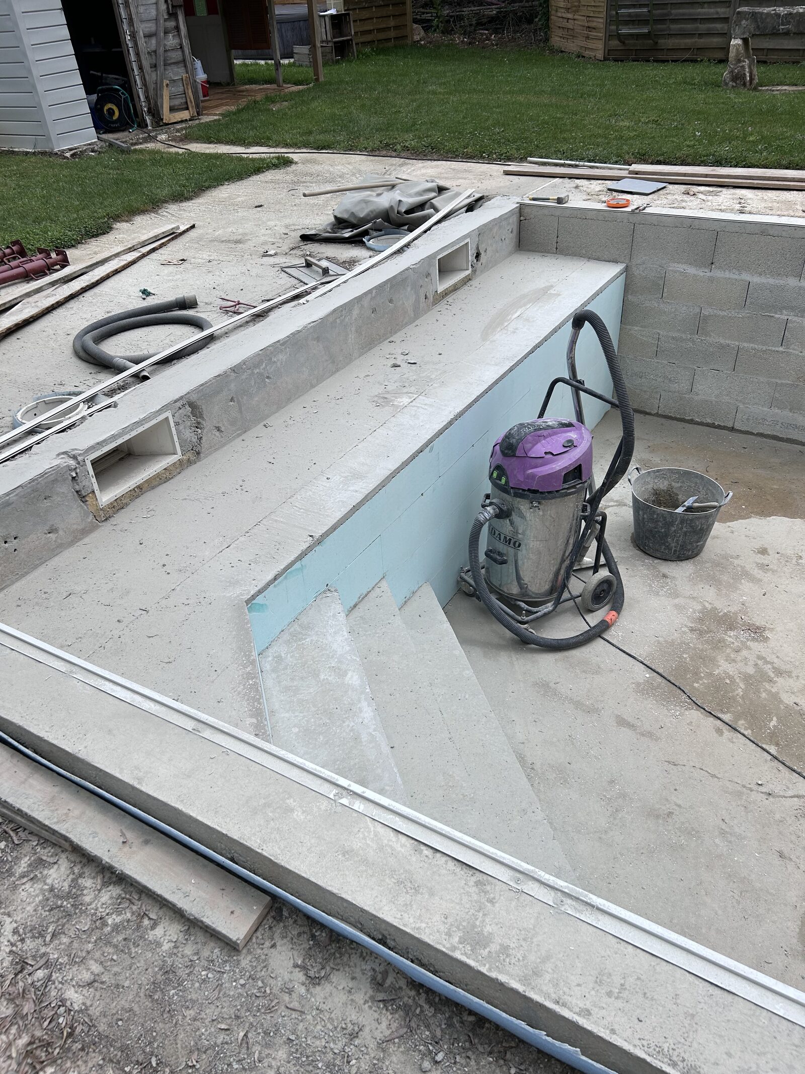 Bassin béton en préparation : escalier, skimmers et isolation avant pose du liner