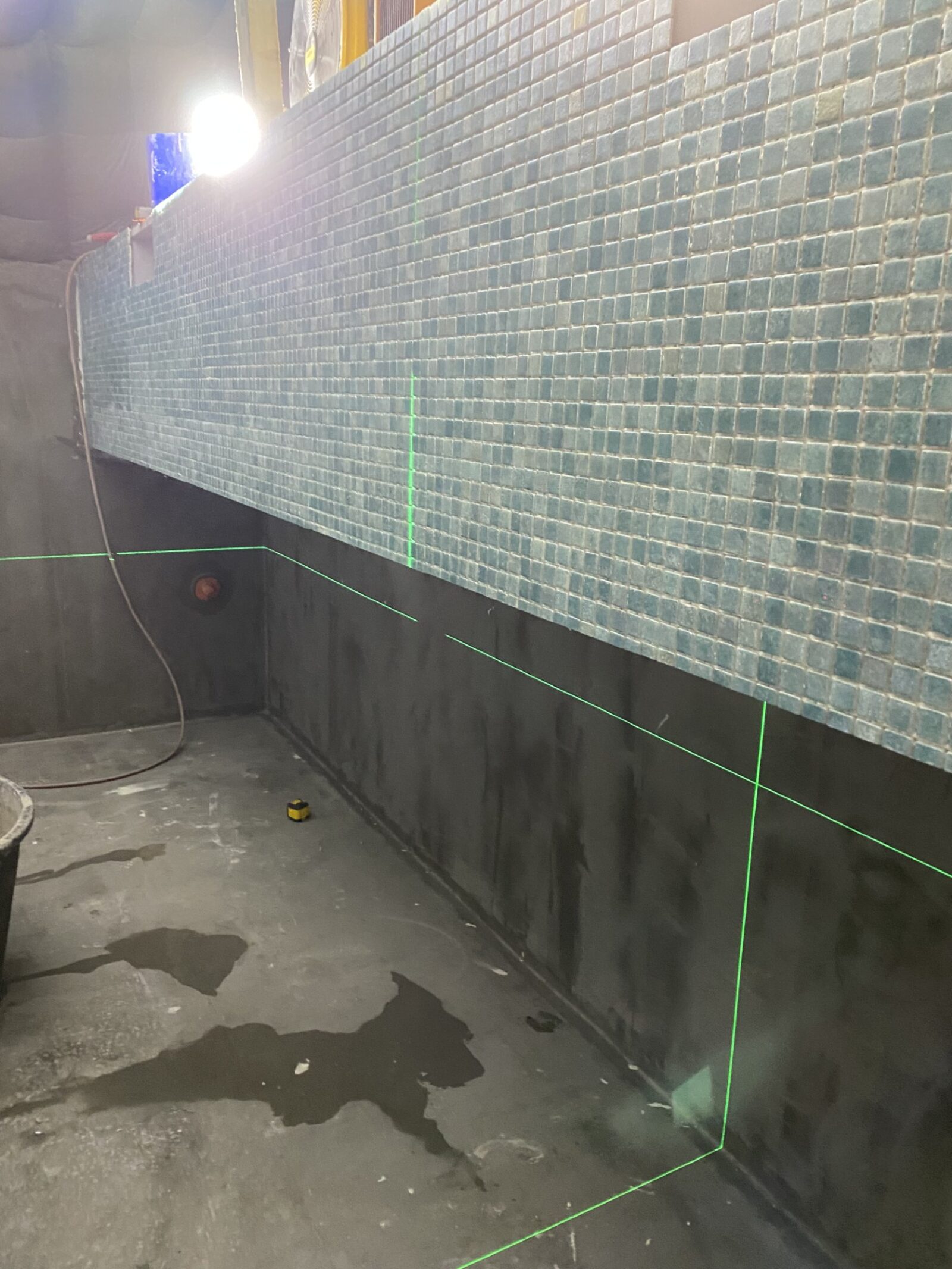 Pose de la mosaïque des parois au laser pour un alignement parfait
