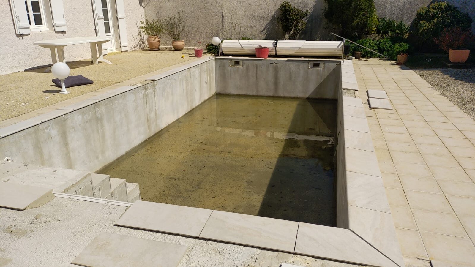 Piscine avant rénovation, bassin vidé et dégradé
