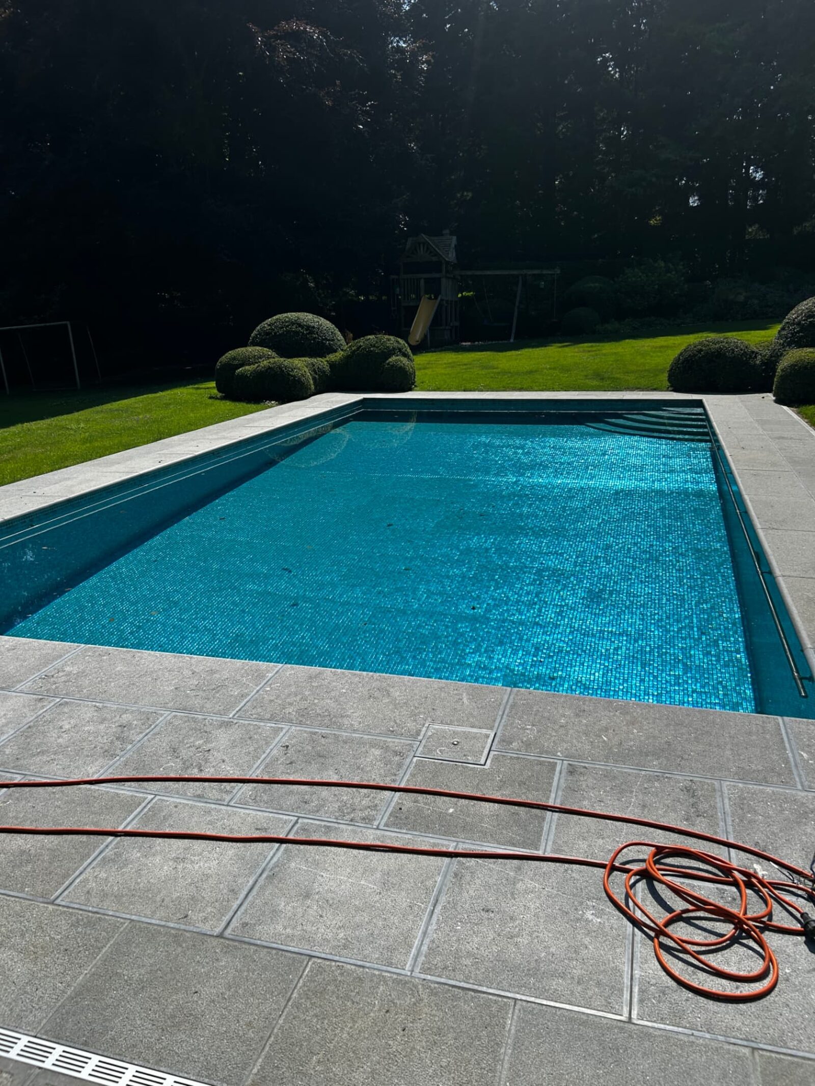 Piscine rénovée en mosaïque de verre et margelles en pierre naturelle